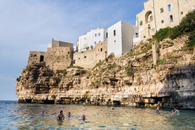 Polignano A Mare, İtalya - 6 Temmuz 2018: Güzel insanlar Lama Monachile, Adriyatik Denizi, Apulia bölgesindeki Bari eyaletinde 6 Temmuz 2018 yılında Polignano a Mare, İtalya üzerinde plaj.