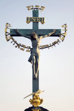 Güzel İsa'nın çarmıha germe bronz heykel gündoğumu, heykel Calvary, Charles Köprüsü, Prague, Çek Cumhuriyeti, güneşli bir gün, St. Haç sırasında açık gökyüzü