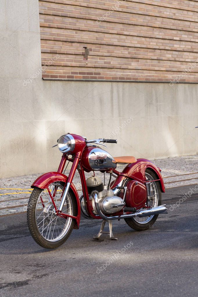 PRAGUE, CZECH REPUBLIC - MARCH 8 2018: Detail of red vintage motorcycle Jawa 125 produced in former Czechoslovakia standing on road on March 8, 2018 in Prague, Czech Republic.