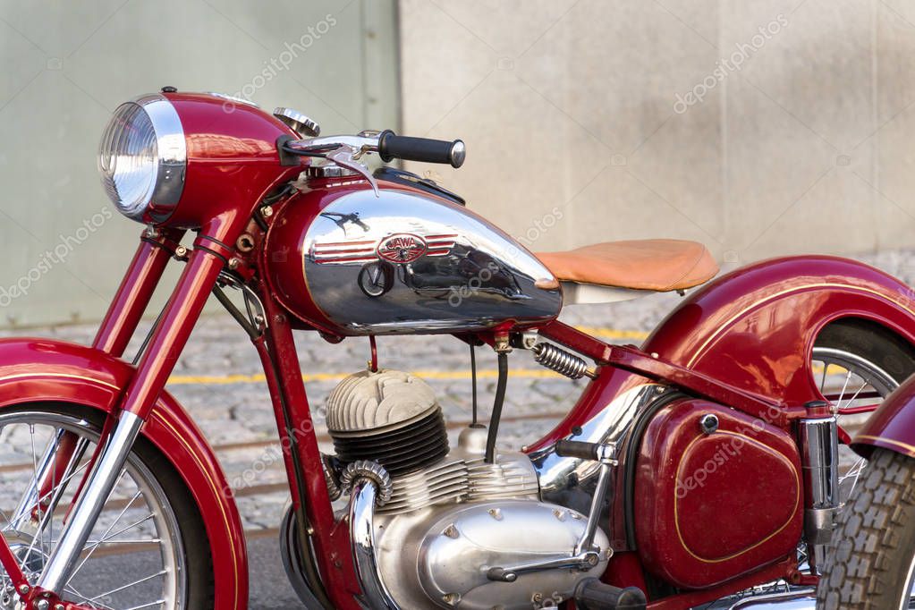 PRAGUE, CZECH REPUBLIC - MARCH 8 2018: Detail of red vintage motorcycle Jawa 125 produced in former Czechoslovakia standing on road on March 8, 2018 in Prague, Czech Republic.