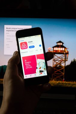 Prague, Çek Cumhuriyeti - 21 Kasım 2018: Airbnb şirket logo üstünde hareket eden app telefon perde ile Internet ana sayfasının arka planda üzerinde 21 Kasım 2018 Prag, Çek Cumhuriyeti. 
