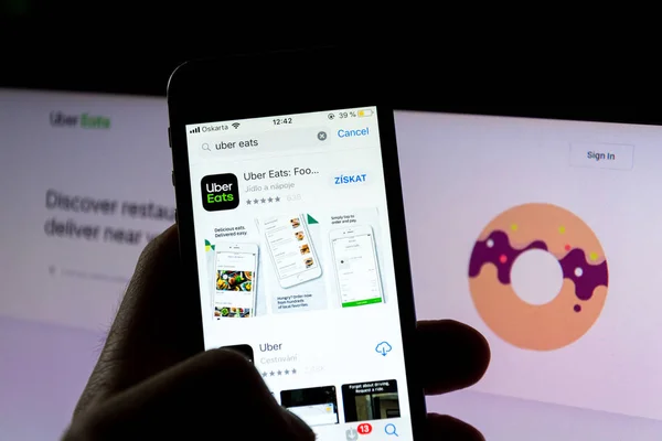 Prag, Tschechische Republik - 21. November 2018: uber isst das Logo des Lebensmittellieferanten auf dem Handy-Bildschirm mit Internet-Startseite im Hintergrund am 21. November 2018 in Prag, Tschechische Republik. — Stockbild Prag Tschechische Republik November 2018 Uber Isst Das Logo Des — Stockfoto