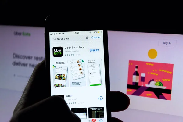 Prag, Tschechische Republik - 21. November 2018: uber isst das Logo des Lebensmittellieferanten auf dem Handy-Bildschirm mit Internet-Startseite im Hintergrund am 21. November 2018 in Prag, Tschechische Republik. — Stockbild Prag Tschechische Republik November 2018 Uber Isst Das Logo Des — Stockfoto