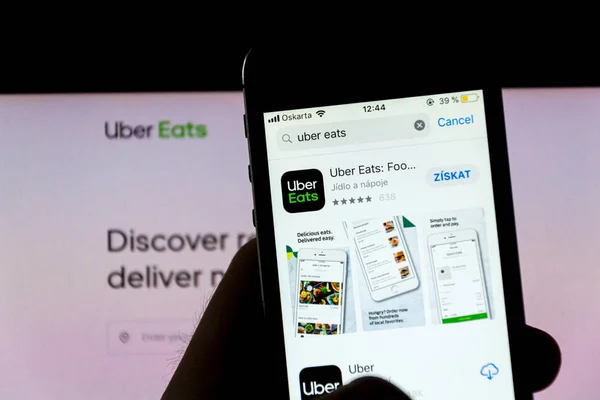 Prag, Tschechische Republik - 21. November 2018: uber isst das Logo des Lebensmittellieferanten auf dem Handy-Bildschirm mit Internet-Startseite im Hintergrund am 21. November 2018 in Prag, Tschechische Republik. — Stockbild Prag Tschechische Republik November 2018 Uber Isst Das Logo Des — Stockfoto