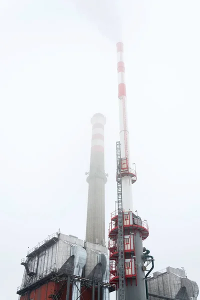 在被雾覆盖 阴天冬日 视角低 能源生产 气候变化和全球变暖概念的供暖厂里的一个新烟囱 — 图库照片