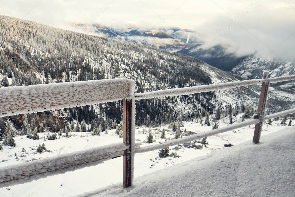 Big hoarfrost on metallic railing with snowy mountains landscape background, Krkonose mountains, Czech republic, freezing weather  