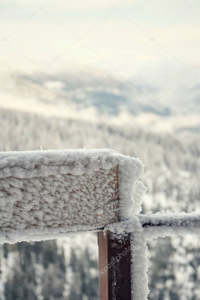 Big hoarfrost on metallic railing with snowy mountains landscape background, Krkonose mountains, Czech republic, freezing weather  
