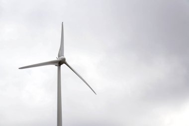 Beyaz rüzgar türbini güç istasyonu, sisli gün, bulutlu gökyüzü, sürdürülebilir yenilenebilir elektrik kavramı üzerinde kopya alanı