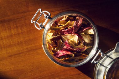 Kurutulmuş elma ve armut yalan ahşap masa, organik meyve gıda, sağlıklı bir yaşam tarzı açık cam