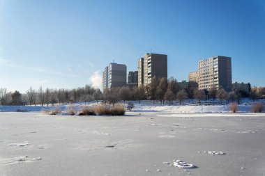 Yalıtımlı panel ev daire ağaçların, daireler, yüksek katlı blok arkasında kule bloklar beton döşeme, büyük panel sistem bina, enerji effeciendy bina kavramı, soğuk hava güneşli dondurucu kış günü Prefabrik