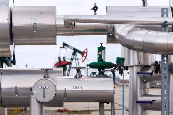 Green and red pumpjack, oil horse, oil derrick pumping oil well with dramatic cloudy sky background