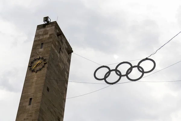 Olympic rings symbol hanging over Olympic stadium from 1936 in Berlin, Germany, dramatic clouds sky background