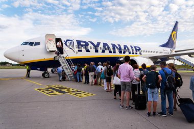 Memmingen, Almanya - 6 Temmuz 2019: Ryanair İrlandalı düşük maliyetli havayolu uçağı Boeing 737'ye binen ler 6 Temmuz 2019 tarihinde Memmingen, Almanya'da bulutlu gökyüzü geçmişi yle.