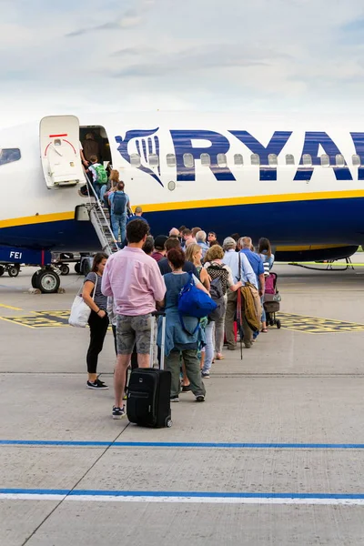 ドイツ ドイツ 2019年7月6日 ドイツ メミンゲンで2019年7月6日に曇り空の背景を持つライアンエアアイルランドの低コスト旅客機ボーイング737に搭乗する人々 — ストック写真