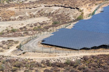 Blue solar panels at photovoltaics power station farm, future innovation energy concept, clear blue sky background, Granadilla, Tenerife clipart