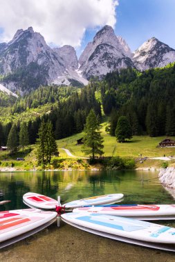 Gosau, Avusturya - 4 Temmuz 2019: 4 Temmuz 2019'da Gosau, Avusturya'da banka yakınlarındaki Vorderer Gosausee gölünün yüzeyinde sörf yapmak.