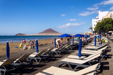 El Medano, İspanya - 7 Temmuz 2019: 7 Temmuz 2019'da İspanya'nın El Medano kentinde playa El Medano plajında yüzen ve güneşlenen insanlar.