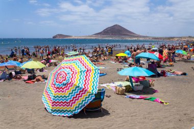 El Medano, İspanya - 7 Temmuz 2019: 7 Temmuz 2019'da İspanya'nın El Medano kentinde playa El Medano plajında yüzen ve güneşlenen insanlar.