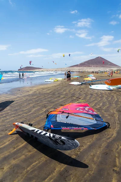 El Medano, İspanya - 7 Temmuz 2019: İnsanlar 7 Temmuz 2019 tarihinde İspanya 'nın El Medano kentinde Granadilla de Abona belediyesinde Playa de Leocadio Machado plajında sörf, uçurtma ve rüzgar sörfü yapıyorlar..
