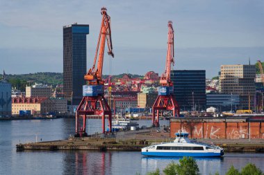Vasttrafik feribotu Gota nehri Alvstaden devolopment şantiyesi Masthuggskajen 'deki Hotel Draken ile 12 Mayıs 2025 tarihinde İsveç' in Göteborg kentinde geçmektedir..