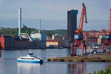 Vasttrafik feribotu Gota nehri Alvstaden devolopment şantiyesi Masthuggskajen 'deki Hotel Draken ile 12 Mayıs 2025 tarihinde İsveç' in Göteborg kentinde geçmektedir..