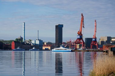 Vasttrafik feribotu Gota nehri Alvstaden devolopment şantiyesi Masthuggskajen 'deki Hotel Draken ile 12 Mayıs 2025 tarihinde İsveç' in Göteborg kentinde geçmektedir..