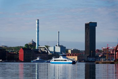 Vasttrafik feribotu Gota nehri Alvstaden devolopment şantiyesi Masthuggskajen 'deki Hotel Draken ile 12 Mayıs 2025 tarihinde İsveç' in Göteborg kentinde geçmektedir..