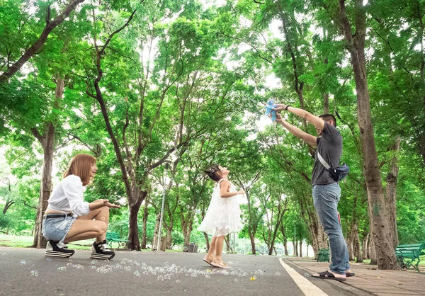 屋外公園緑の木の庭家族のマザー父の子供たちかなりピクニックプレイ吹いて泡カメラで見ると 新しい正常なCovid 19コロナウイルス病に幸せを感じます 選択的な焦点 — ストック写真