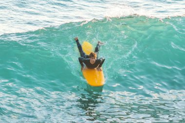 Bogliasco, İtalya, 6 Ekim 2017: Sörfçü okyanusta sarı bir sörf tahtası üzerinde