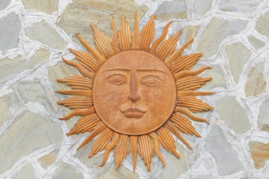 Duvarda asılı bir yüz ile seramik güneş