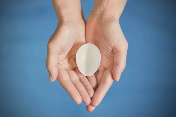 Witte Eggshell Handen Een Blauwe Achtergrond — Stockfoto