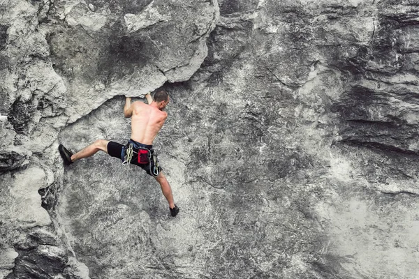 崖にぶら下がっている若い男性登山 コピースペース — ストック写真