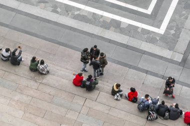 Milan, İtalya, 10 Kasım 2017: Grup bir taş merdiven, üstten görünüm oturan insan