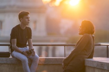 Roma, İtalya, 21 Ekim 2017: iki genç çocuklar balkonda günbatımı sırasında söz