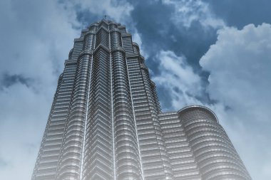 Bulutlu gökyüzü arka plan üzerinde modern gökdelenin alttan görünüm