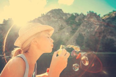 Genç kız açık havada sabun köpüğü üfleme