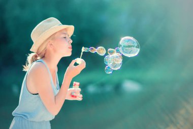 Genç kız açık havada sabun köpüğü üfleme