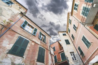 Bulutlu gökyüzü, bir parçası ile İtalya sokaklarında eski evleri göster altından