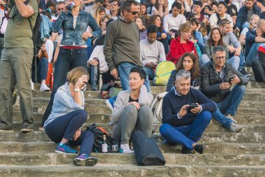 Floransa, İtalya, 12 Ekim 2017: Fotoğraf makinesi ve taş basamaklarında oturan telefon ile kişilik bir kalabalık