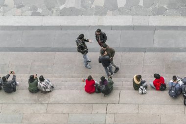 Milan, İtalya, 10 Kasım 2017: Grup bir taş merdiven, üstten görünüm oturan insan