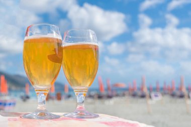İki cam bardak ile sahilde bira