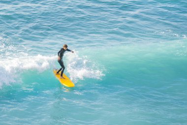 Bogliasco, İtalya, 6 Ekim 2017: Sörfçü bir dalga sürme sarı sörf tahtası üzerinde