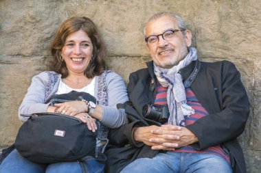 Floransa, İtalya, 12 Ekim 2017: Gülümseyen orta yaşlı adam ve taş bir duvara yakın oturan kadın