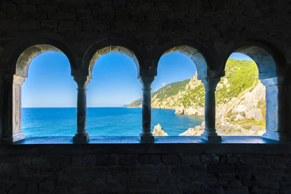 Sea view through the ancient stone arched window