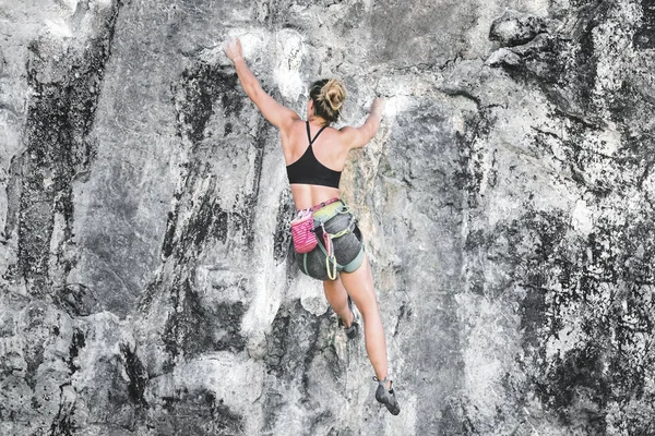 若い登山家の女性は ベレー機器なしで崖を登る — ストック写真