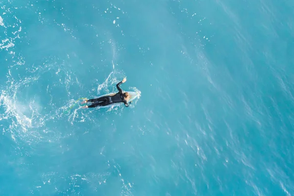 Surfer in the ocean, top view