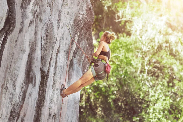 晴れた夏の日に安全ロープで崖を登る女性登山者 — ストック写真