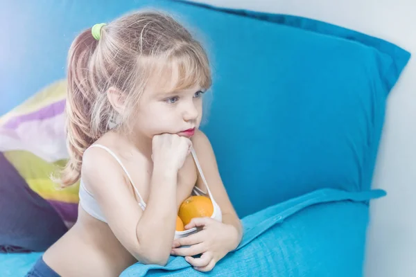 Little Blonde Girl Painted Lips Two Oranges Top Sitting Blue — Zdjęcie stockowe