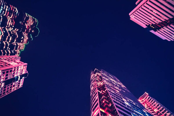 A modern night city. Skyscrapers with pink illumination