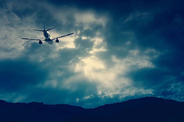 Літак Пролітає Крізь Драматичне Хмарне Небо Над Гірським Хребтом Горизонті — стокове фото